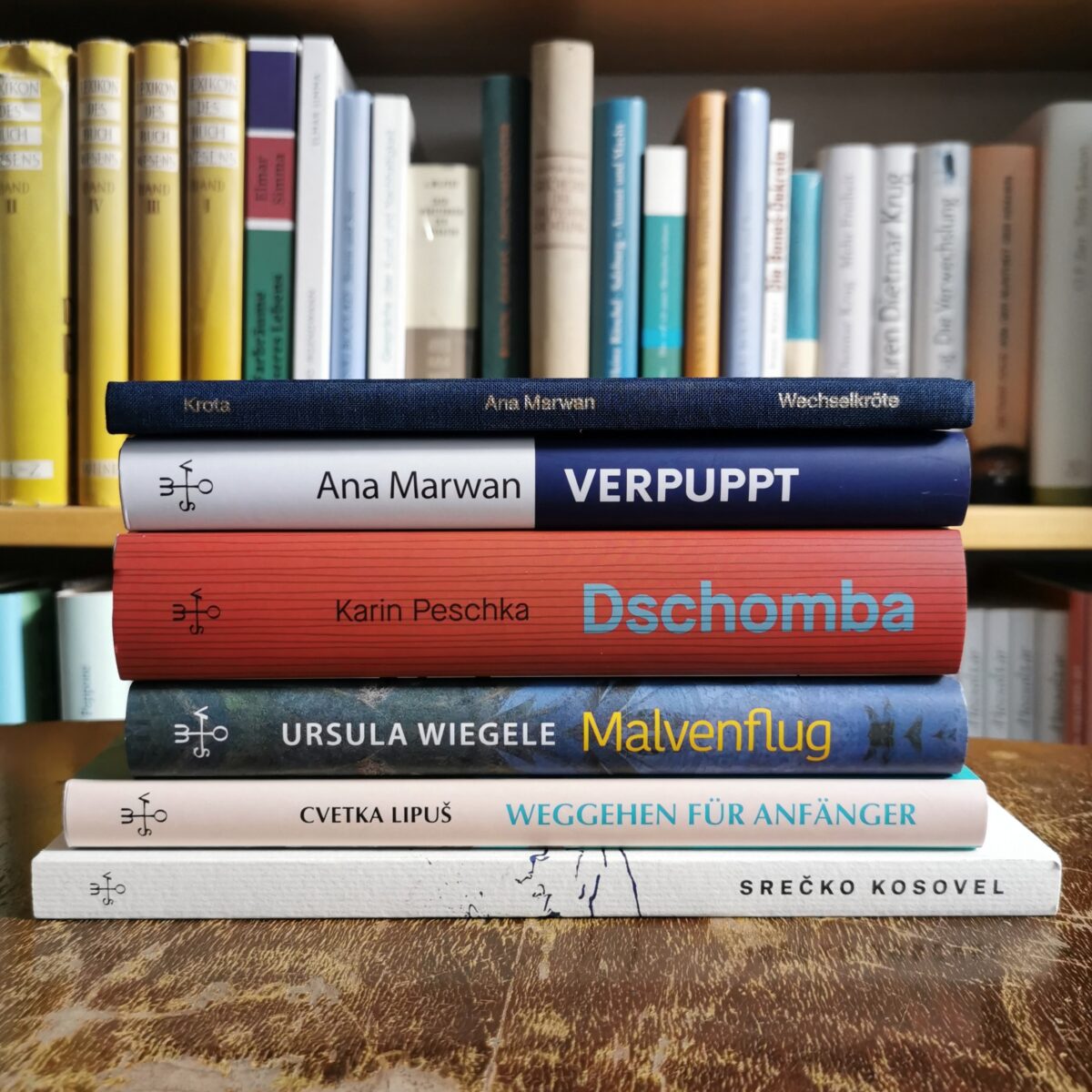 Bücherstapel bestehend aus "Wechselkröte" und "Verpuppt" von Ana Marwan, "Dschomba" von Karin Peschka, "Malvenflug" von Ursula Wiegele, "Weggehen für Anfänger" von Cvetka Lipus und "Mein Gedicht ist mein Gesicht" von Srecko Kosovel